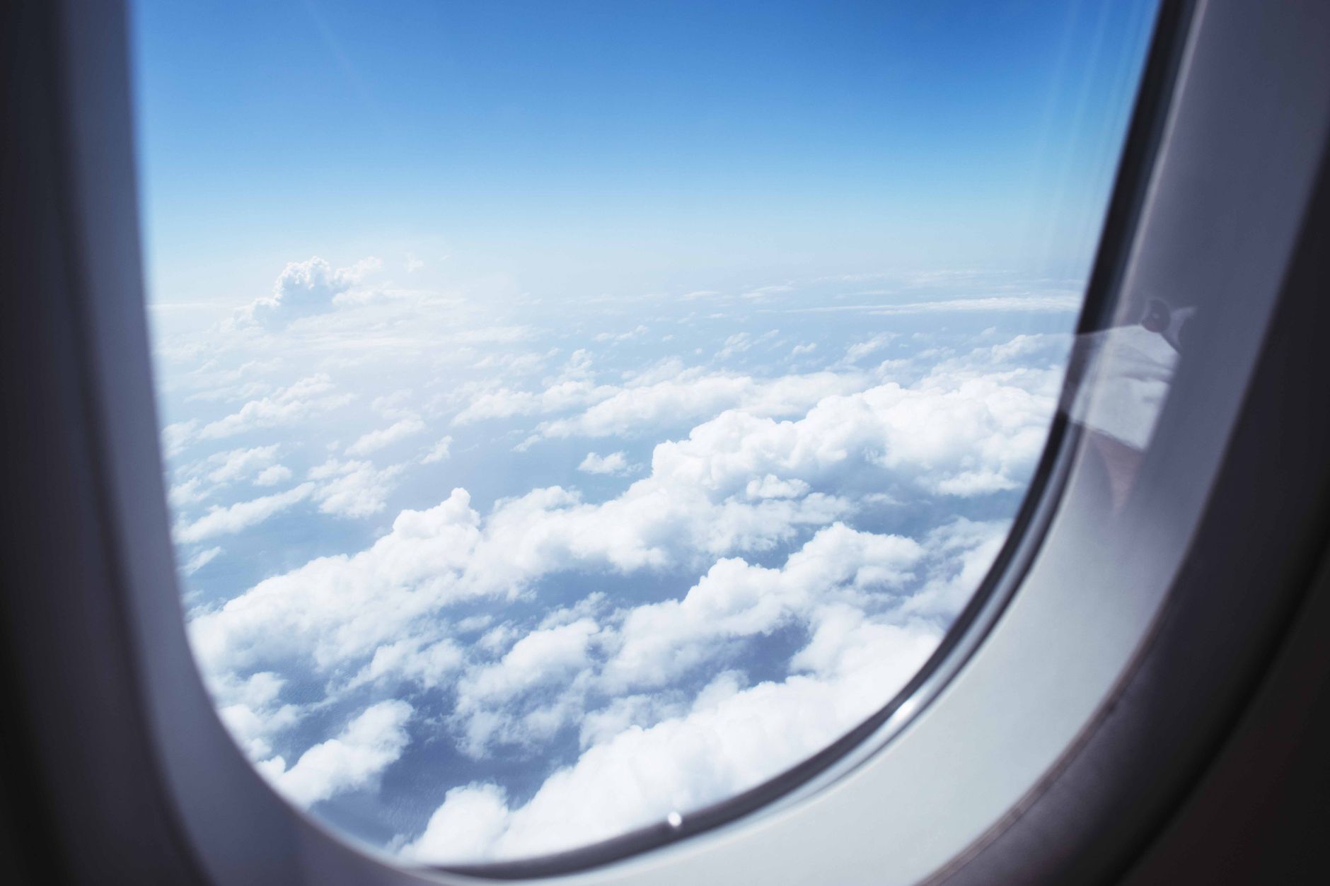 A view out of an airplane window above the clouds